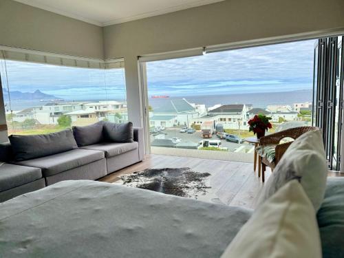 een woonkamer met een bank en een groot raam bij BB BEACH BAY QUALITY APARTMENTs in Cape Town