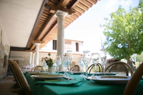 a table with a green table cloth and wine glasses at Don Carlo Agriturismo di Charme Bio in Le Pioppe