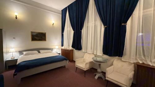 a bedroom with a bed and a desk and chairs at Vila Băncii 1888 by SunGarden in Băile Herculane