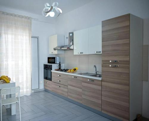 Eleven Home في باري: مطبخ مع خزائن خشبية وفرن موقد