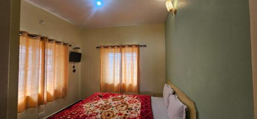 乌提OOTY STAY AWHILE的卧室里有一张床，上面铺着一条红毯子