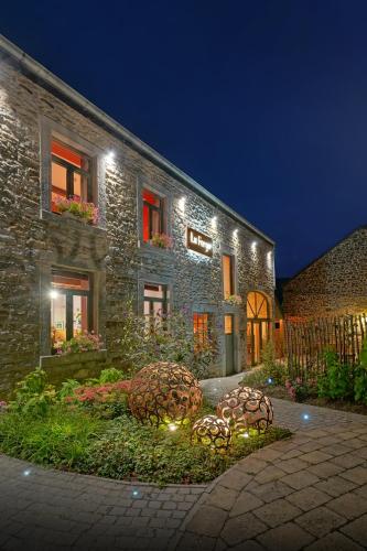 a stone house with lights in front of it at La Forge - Chambres d'hôtes en Ardenne in Wellin