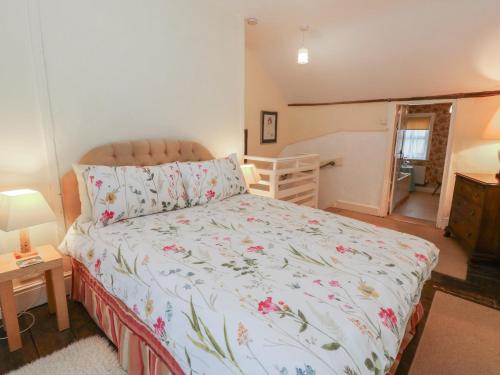 a bedroom with a bed with a floral bedspread at 6 Church Lane in Llanidloes