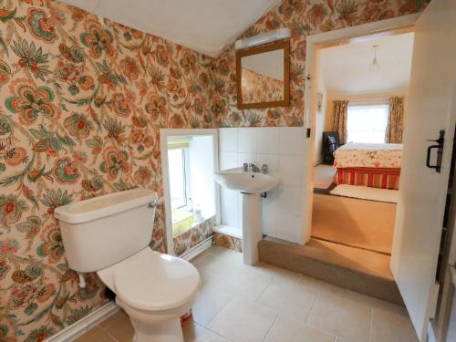 a bathroom with a toilet and a sink and a bedroom at 6 Church Lane in Llanidloes