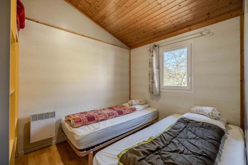 RoquefeuilChalet montana 2- 4pers的一间带窗户的小房间里有两张床