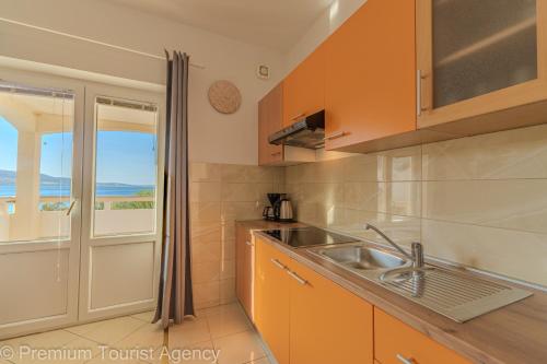 a kitchen with a sink and a view of the ocean at Sladana direct at the beach in Metajna