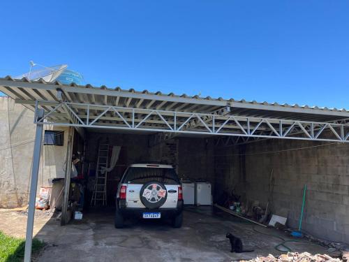 Un garaje con un camión blanco estacionado en él. en Casa Girassol, en Ametista do Sul