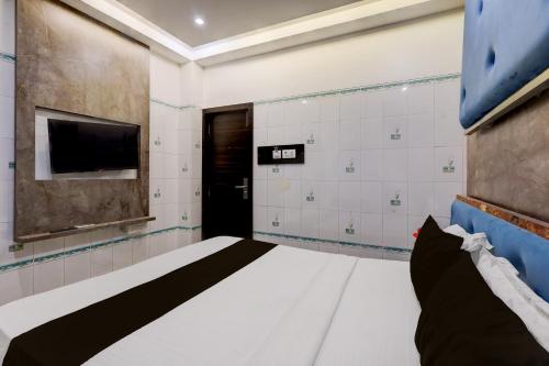 Habitación con cama, TV y puerta. en Collection O Chidambaram Stadium Formerly Hotel Admire Suit, en Chennai
