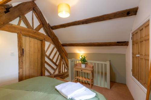 Capel GarmonSnowdonia Cottage 10 mins to Betws Y Coed的一间卧室设有一张绿色的床和木梁。