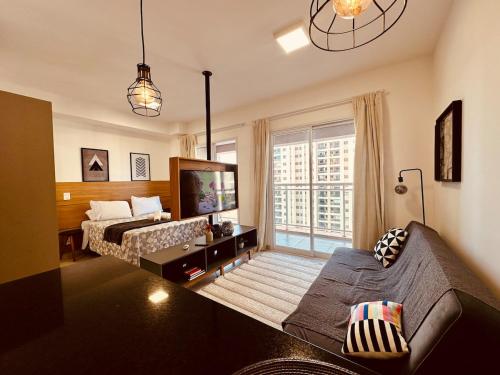 a living room with a couch and a tv at Madrid 1101 in Sao Jose do Rio Preto