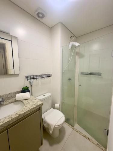 a bathroom with a toilet and a glass shower at Madrid 1101 in Sao Jose do Rio Preto