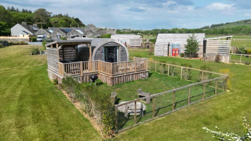 an outside view of a tiny house in a field at The Galloway Steading -The Hedgehog's Hideout family cabin with Hot Tub and Fire Pit in Glenluce