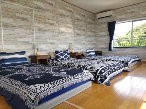 duas camas em um quarto com uma parede de tijolos em Pension Le Passage - Vacation STAY 53145v em Tottori