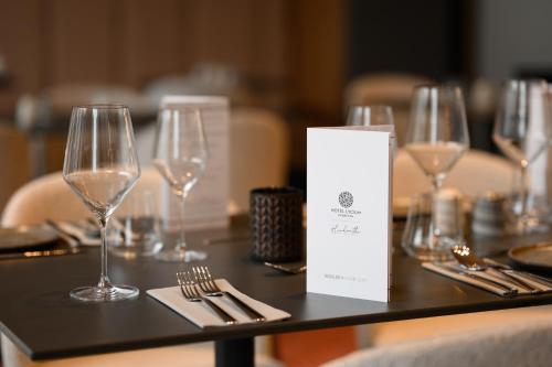 a table with wine glasses and silverware on it at Hotel Lycium Debrecen - Handwritten Collection in Debrecen