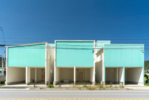 a large building with blue windows on a street at Grandioso Okinawa Villa Kin 2 - Vacation STAY 63972v in Yaka