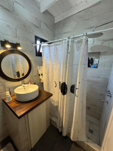 a bathroom with a sink and a shower with a mirror at Casa 109 in Necochea