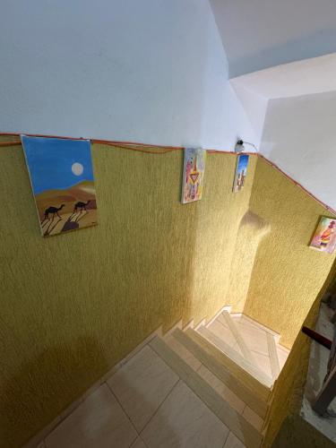 uma escada em uma sala com pôsteres nas paredes em Hostel dallas Warzazate em Ouarzazate