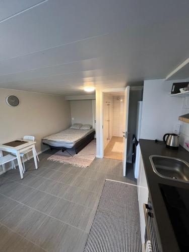 Una pequeña habitación con una cama y una cocina. en Apartment with open floor plan, en Gävle