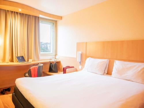 a bedroom with a large white bed and a window at ibis Nantes Centre Gare Sud in Nantes