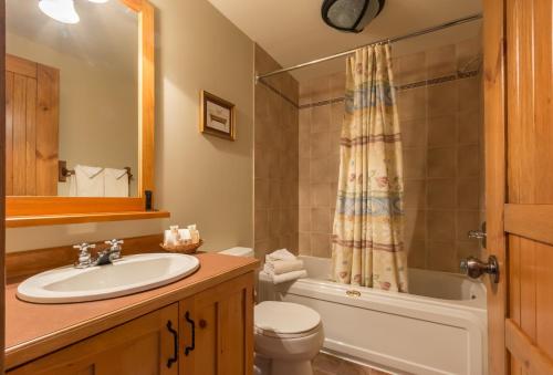 a bathroom with a sink and a toilet and a shower at Les Falaises by Rendez-Vous Mont-Tremblant in Mont-Tremblant