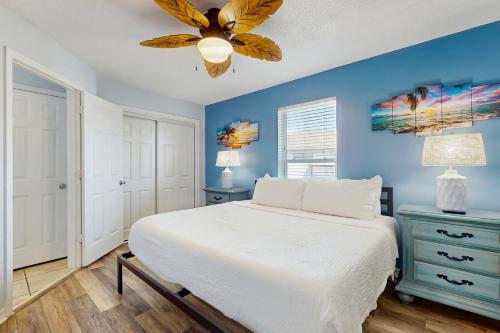 een slaapkamer met een wit bed en een blauwe muur bij Gulf Island Condo 523 in Navarre