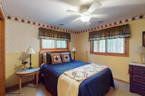 una camera da letto con un letto e un ventilatore a soffitto di Manitowish Mike’s a Manitowish Waters