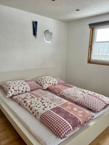 a bed with four pillows on it in a room at Ferienwohnung Fink in Langenegg