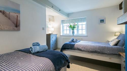 a bedroom with two beds and a window at Hafan in Beaumaris