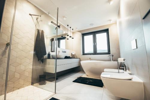 a bathroom with a tub and a sink and a toilet at Lenneapartments Premium in Plettenberg