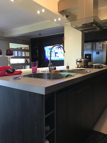 a kitchen counter with a sink and a tv at casa celeste in Puerto Montt