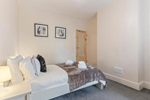 a bedroom with a large bed with white walls at 3 Bed House in Leicester, by ARP Homes, Close to M1 & M69, Free Parking, Perfect for Contractors and Long Stays in Leicester