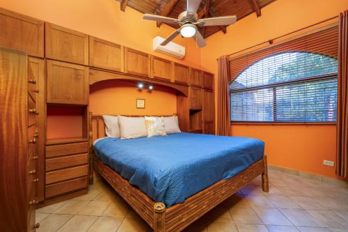 Un dormitorio con una cama y un ventilador de techo. en BBQ, Pool, Garden, Smart TV, Parking, AC, King Bed, Laundry facilities - Villaggio 376, en Potrero