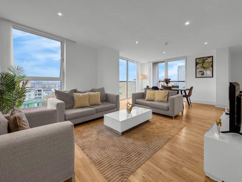 a living room with two couches and a table at MySquare Lanterns Way Apartments at Canary Wharf in London