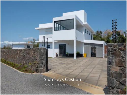 una gran casa blanca con un muro de piedra en SG19 Villa Serenity Lux, en Calodyne