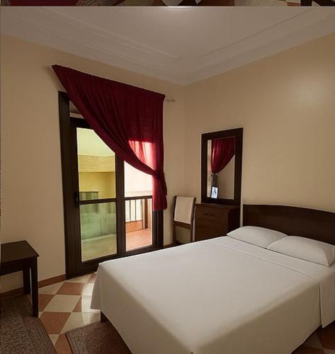 a bedroom with a large white bed and a window at Hotel Estrella del Norte in Larache