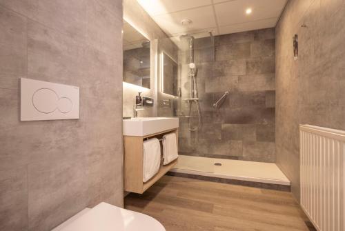 a bathroom with a toilet and a sink and a shower at Fletcher Boutique Hotel De Kromme Dissel in Heelsum