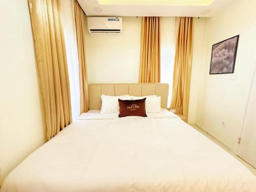 a large white bed in a room with a window at LinQues & Bethel Residences in Ibadan