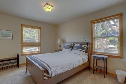 a bedroom with a large bed and two windows at Hutson's Bridgeview 30 Day in Hood River