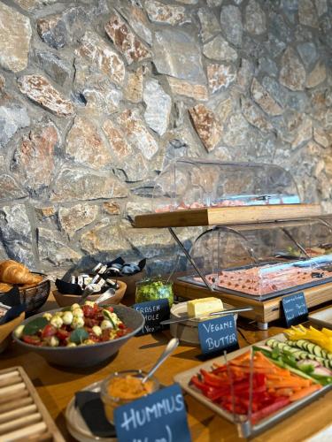 Ein Tisch mit verschiedenen Speisen auf einer Steinmauer in der Unterkunft Puitalm Apartments & SPA by Peak Stay in Arzl im Pitztal