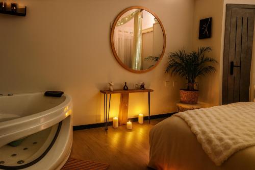 un baño con bañera y espejo en Rendez-vous Secret, en Lunas