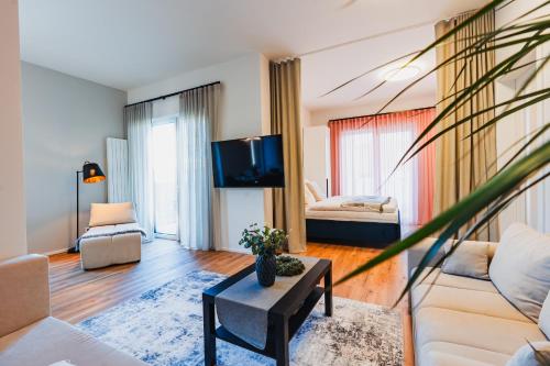 Una sala de estar con un sofá y un televisor. en Prázdninová rezidence - 2 ložnice, 2 terasy, 90m2, en Komárov