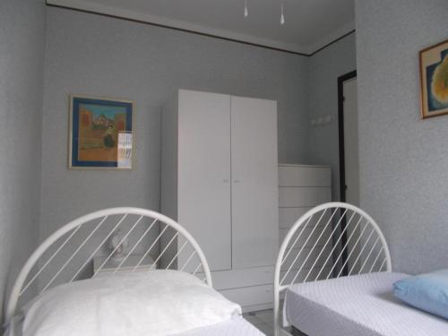 ヴィッラピアーナにあるLa Ginestraのベッドルーム1室(白い椅子2脚、ベッド1台付)