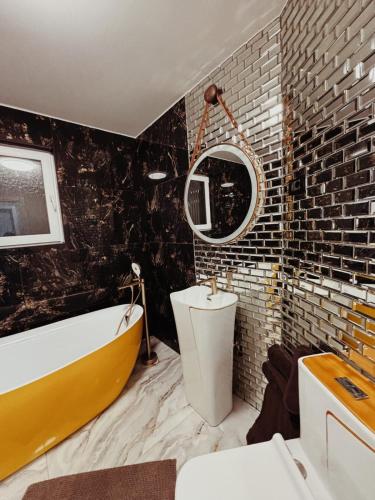 a bathroom with a yellow tub and a yellow sink at GZP Residence Lugoj 4 in Lugoj
