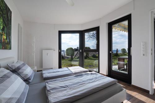 a bedroom with a bed and a large window at Seepanorama in Unteruhldingen