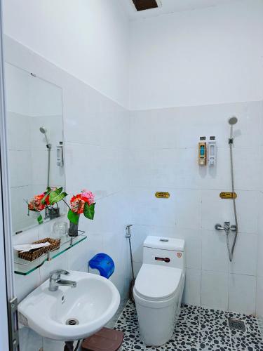 a bathroom with a white toilet and a sink at Dalat Hills Apartment in Da Lat