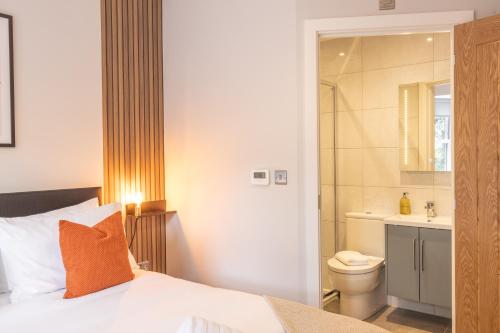 a bedroom with a bed and a bathroom with a toilet at 4 Bed House in Coventry City Centre, by ARP HOMES, Driveway & Garage, Big Garden, Ideal for Contractors, Families and Long Stays in Coventry