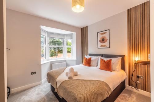 a bedroom with a large bed with orange pillows at 4 Bed House in Coventry City Centre, by ARP HOMES, Driveway & Garage, Big Garden, Ideal for Contractors, Families and Long Stays in Coventry