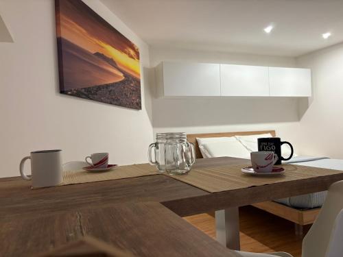 a dining room table with two mugs on top of it at Anxur Apartment in Terracina