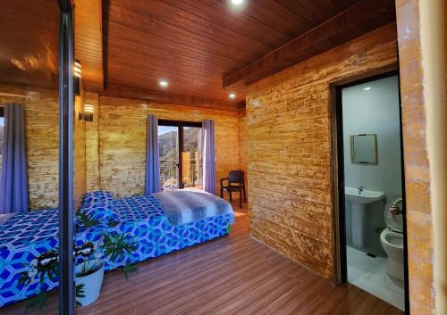 a bedroom with a bed and a bathroom with a toilet at Forest Valley Homestay in La Trinidad