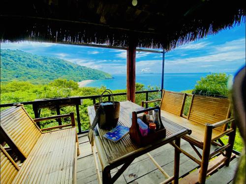 Una mesa en una terraza con vista al océano. en Baan Amila, en Phra Ae beach
